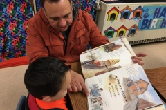 Father and son doing a picture walk together through the book